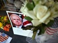 Photographs, flowers and notes gather at a makeshift memorial to U.S. Senator John McCain outside his office in Phoenix, Arizona, on August 26, 2018.