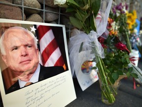 Photographs, flowers and notes gather at a makeshift memorial to U.S. Senator John McCain outside his office in Phoenix, Arizona, on August 26, 2018.