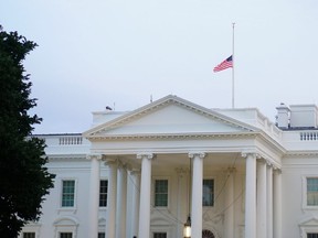 The U.S. flag above the White House flies at half-staff in the evening in Washington, DC, on August 27, 2018.