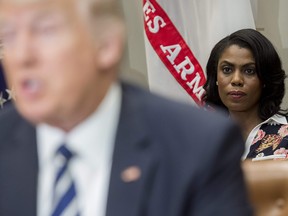 This file photo taken on February 14, 2017 shows Omarosa Manigault (R), White House Director of Communications for the Office of Public Liaison, sitting behind US President Donald Trump as he speaks during a meeting with teachers, school administrators and parents in the Roosevelt Room of the White House in Washington, DC.