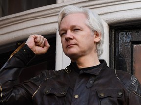 This file photo taken on May 19, 2017 shows Wikileaks founder Julian Assange raising his fist prior to addressing the media on the balcony of the Embassy of Ecuador in London.
