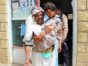 A man transports a child to a hospital after he was wounded in a reported air strike on the Iran-backed Huthi rebels' stronghold province of Saada Aug. 9, 2018.