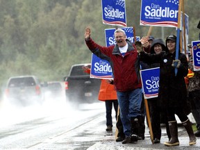 Dan Saddler waves to cars alongside Eagle River Loop Road on Tuesday, Aug. 21, 2018, in Eagle River, Alaska. Saddler is running in the Republican primary for State Senate District G.