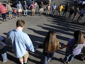 Opponents of a decision to quit playing "Dixie" as the high school fight song pray before a city school board meeting in Arab, Ala., on Thursday, Aug. 30, 2018. Critics of the decision, who also want to resume public prayers before high school football games, say the song is a small-town tradition and disagree with critics who depict "Dixie" as an anthem of slavery and racism.