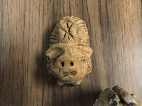 This undated photograph provided by the Mobile Police Department in Mobile, Ala., shows a carving that was inside a briefcase that was found by a citizen and turned in to officers recently. Investigators are trying to locate the owner of the case, which included other items including what appeared to be ancient fossils. (Mobile Police Department via AP)