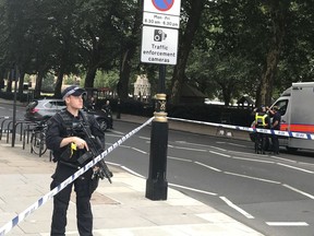 Police  patrol on Millbank, in central London, after a car crashed into security barriers outside the Houses of Parliament, in London,  Tuesday, Aug. 14, 2018. London police say that a car has crashed into barriers outside the Houses of Parliament and that there are a number of injured.