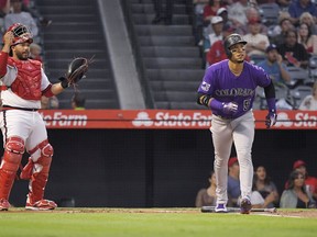 Colorado Rockies' Carlos Gonzalez, right, runs to first as he hits a two-run home run while Los Angeles Angels catcher Rene Rivera watches during the first inning of a baseball game, Tuesday, Aug. 28, 2018, in Anaheim, Calif.