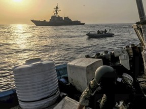 In this photo made available Thursday, Aug. 30, 2018, a team from the guided-missile destroyer USS Jason Dunham inspects a dhow while conducting maritime security operations. A U.S. military video released early Friday, Aug. 31, 2018, purported to show small ships in the Gulf of Aden smuggling weapons amid the ongoing war in Yemen, with officials saying they seized over 1,000 arms from the vessels. (U.S. Navy via AP)