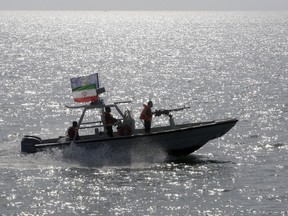 FILE - In this Monday, July 2, 2012, file photo, an Iranian Revolutionary Guard speedboat escorts a passenger ship, unseen, near the spot where an Iranian airliner was shot down by a U.S. warship 24 years ago killing 290 passengers. A false claim by Yemen's Houthi rebels of an attack on Dubai International Airport, the world's busiest airport for international travel, this week may have been quickly disproven by authorities in Dubai, but it shows the looming threats in the region.