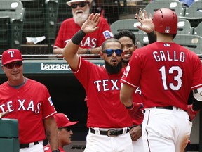 From left, Texas Rangers manager Jeff Banister, Rougned Odor and Elvis Andrus congratulate Joey Gallo (13) after his second home run against the Seattle Mariners during the fifth inning of a baseball game Wednesday, Aug. 8, 2018, in Arlington, Texas.