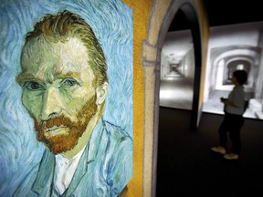 A visitor walks past an image of Van Gogh's "Self-Portrait" during a press event for the world premiere of the Meet Vincent Van Gogh exhibit in Beijing, China on June 15, 2016.