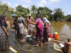 Residents wash household goods after salvaging them from sludge and muck accumulated inside their flood affected houses on the outskirts of Kochi in the southern state of Kerala, India, Tuesday, Aug. 21, 2018. The Indian military is scaling down rescue operations in this tropical tourist haven where intense floods killed more than 200 people and drove hundreds of thousands from their homes.