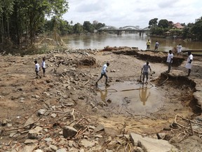 People assess damage caused by floods on the outskirts of Kochi in the southern state of Kerala, India, Wednesday, Aug. 22, 2018. Torrential downpours began hammering Kerala on Aug. 8, more than two months into the annual monsoon season, setting off devastating floods that left more than 200 people dead and sent more than 800,000 fleeing for dry land.