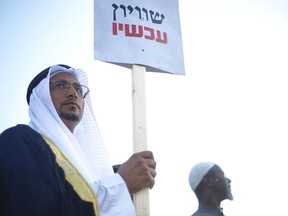 An Arab Israeli Arab man holds a sign that reads "Equality now" during a protest against the Jewish nation bill in Tel Aviv, Israel, Saturday, Aug. 11, 2018. The recently passed law that enshrines Israel's Jewish character and downgrades the standing of Arabic from an official to a "special" language.