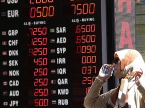 A woman checks the currency exchange rates at a currency exchange shop in Istanbul, Monday, Aug. 13, 2018. Turkey's central bank announced a series of measures on Monday to free up cash for banks as the country grapples with a currency crisis. The Turkish lira has nosedived over the past week and tumbled another 7 percent on Monday as the central bank's measures failed to restore investor confidence.