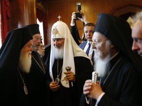 Patriarch Kirill of Moscow, centre, is introduced to officials by Ecumenical Patriarch Bartholomew I, right, the spiritual leader of the world's Orthodox Christians, prior to their meeting at the Patriarchate in Istanbul, Friday, Aug. 31, 2018. Bartholomew I is currently debating whether to accept a Ukrainian bid to tear that country's church from its association with Russia, a potential split fuelled by the armed conflict between Ukrainian military forces and Russia-backed separatists in eastern Ukraine.