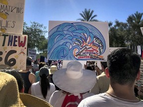 In this June 30, 2018, photo, protesters rally at a Keep Families Together march at the Arizona state Capitol in Phoenix. The blue wave Democrats hope will crash into Arizona this November is creeping up in community centers, library auditoriums and churches.