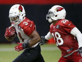 Arizona Cardinals running back David Johnson (31) runs with the ball as the tries to elude defensive back Jamar Taylor (28) during an NFL football practice Monday, Aug. 13, 2018, in Glendale, Ariz.