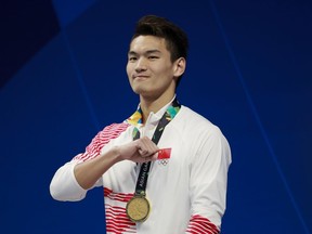 China's Xu Jiayu celebrates after winning the men's 200m backstroke gold medal during the swimming competition at the 18th Asian Games in Jakarta, Indonesia, Thursday, Aug. 23, 2018.