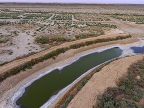 This Saturday, July 28, aerial photo shows a dry canal full of salt in the area of Siba in Basra, 340 miles (550 km) southeast of Baghdad, Iraq. Iraq, historically known as The Land Between The Two Rivers, is struggling with the scarcity of water due to dams in Turkey and Iran, lack of rain and aging hydrological infrastructure. The decreased water levels have greatly affected agriculture and animal resources.
