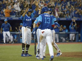 Curtis Granderson, left. and Blue Jays teammates Lourdes Gurriel Jr and Danny Jansen celebrate teammate Aledmys Diaz's three-run double against the Philadelphia Phillies during the eighth inning of their game Saturday night at Rogers Centre in Toronto.