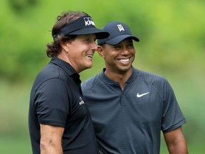 Phil Mickelson (left) and Tiger Woods smile during a practice round prior to the World Golf Championships-Bridgestone Invitational in Akron, Ohio, on Aug. 1.