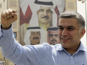 FILE - In this May 28, 2012 file photo, human rights activist Nabeel Rajab gestures as he leaves a police station in Manama, Bahrain.  A United Nations panel said Thursday Aug. 16, 2018, Bahrain should immediately release imprisoned activist Nabeel Rajab. Rajab is serving a five-year prison sentence for tweets he sent in a case widely criticized internationally as the kingdom's government continues a crackdown on dissent. Images on the building at rear shows, clockwise from top, King Hamad bin Isa Al Khalifa, Crown Prince Salman bin Hamad Al Khalifa and Prime Minister Khalifa bin Salman Al Khalifa.