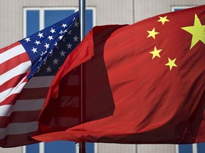 FILE - In this Sept. 5, 2012, file photo, U.S. and China's national flags flutter in winds at a hotel in Beijing. China has denied an accusation by U.S. President Donald Trump that it hacked the emails of Hillary Clinton, his Democratic opponent in the 2016 election.