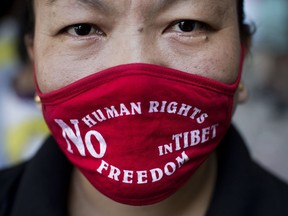 FILE - In this Sept. 17, 2014, file photo, an Exile Tibetan woman wears a mask during a protest to highlight Chinese control over Tibet, coinciding with the visit of Chinese President Xi Jinping in New Delhi, India. A top Chinese leader has called for "advancing anti-separatism efforts" in Tibet, in a sign of continued high-pressure tactics in ruling the Himalayan region.
