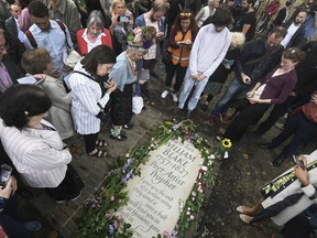 People gather around a newly unveiled headstone for English poet William Blake at Bunhill Fields in London after it is unveiled, Sunday Aug. 12, 2018. The lost grave of William Blake is marked with a new gravestone, nearly two centuries after the poet and painter was buried in an unmarked common grave in Bunhill Fields. There was a plain memorial stone in the cemetery that simply recorded that the artist was buried nearby, but the exact site of Blake's grave was lost to history until it was re-discovered by two members of the Blake Society in 2006.