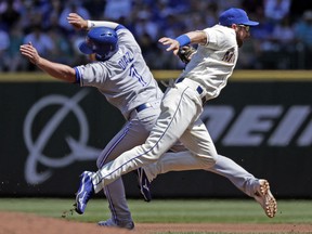 Mariners second baseman Andrew Romine, right, tags Toronto Blue Jays' Aledmys Diaz on the fly as Diaz heads to first base before completing the double play in the second inning of a their game on Sunday in Seattle.