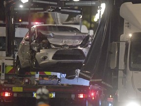 Police recover the car that crashed into security barriers from the scene outside the Houses of Parliament, Westminster in London, Tuesday Aug. 14, 2018.