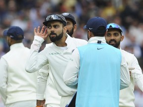 Indian cricket captain Virat Kohli cups his ears as he celebrates with teammates after the dismissal of England's Chris Woakes during the second day of the third cricket test match between England and India at Trent Bridge in Nottingham, England, Sunday, Aug. 19, 2018.