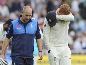 England's Jonny Bairstow leaves the field with a medic after injuring his finger while collecting the ball during the third day of the third cricket test match between England and India at Trent Bridge in Nottingham, England, Monday, Aug. 20, 2018.
