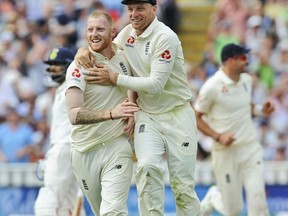 England's Ben Stokes, left, is congratulated by teammate Jos Buttler for dismissing India's Lokesh Rahul during the third day of the first test cricket match between England and India at Edgbaston in Birmingham, England, Friday, Aug. 3, 2018.