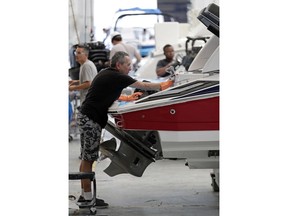 FILE - In this July 11, 2018 file photo, workers put finishing touches on boat exteriors at Regal Marine Industries in Orlando, Fla. American boat makers are getting pummeled on multiple fronts by tariffs and stand to be among the industries hardest-hit by the escalating trade war.