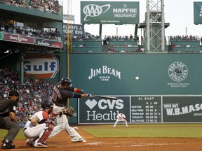 Cleveland Indians' Edwin Encarnacion hits a two-run home run against the Boston Red Sox during the first inning of a baseball game Wednesday, Aug. 22, 2018, in Boston.