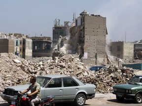 In this July 31, 2018 photo, heavy machinery is used to demolish buildings, in the Maspero neighborhood of Cairo, Egypt. Egyptian authorities are demolishing the historical 19th century neighborhood in Cairo to make way for high-end housing and business development a stone's throw from the Nile, angering residents who say they have not been properly compensated. Maspero is named for French Egyptologist Gaston Maspero who helped found the Egyptian Museum.