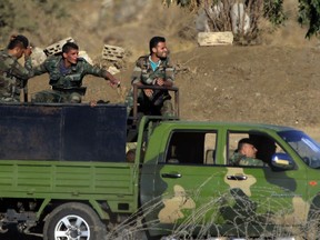 FILE - In this Thursday, July 26, 2018 file photo, Syrian soldiers arrive to Syria's Quneitra border crossing between Syria and the Israeli-controlled Golan Heights. Russian President Vladimir Putin's envoy to Syria says Iran-backed fighters have withdrawn more than 80 kilometers (50 miles) from Syria's frontier with the Israeli-occupied Golan Heights in order not to "irritate" Israel. Alexander Lavrentyev told the Russian Interfax news agency on Wednesday, Aug. 1, that an agreement was reached "with Russian guarantees," without elaborating.