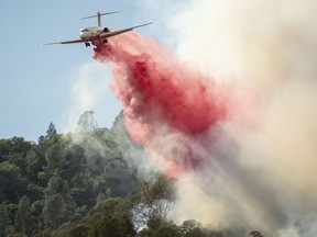 An air tanker drops fire retardant on a burning hillside in the Ranch Fire in Clearlake Oaks, Calif., Sunday, Aug. 5, 2018.