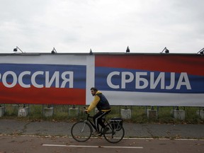 In this Friday, Oct. 17, 2014. file photo, a man riding bicycle pasts a billboards reading 'Russia' , left and 'Serbia', in Belgrade, Serbia. After a public outcry, Serbia police on Friday Aug. 17, 2018, closed a summer youth camp on a mountain in western Serbia organized by Russian and Serbian far-right groups.