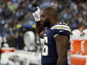 Los Angeles Chargers offensive tackle Russell Okung raises his fist during the playing of the national anthem before the team's NFL preseason football game against the Seattle Seahawks on Saturday, Aug. 18, 2018, in Carson, Calif.