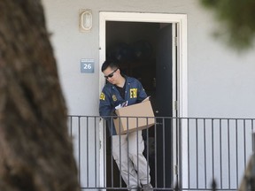 A federal agent removes items from an apartment following the arrest of Omar Ameen, Wednesday, Aug. 15, 2018, in Sacramento, Calif. Ameen, a 45-year-old Iraqi refugee, was arrested on a warrant alleging that he killed an Iraqi policeman in 2014 while serving with the Islamic State terror organization.