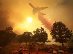 A 747 Global Airtanker makes a drop in front of advancing flames from a wildfire Thursday, Aug. 2, 2018, in Lakeport, Calif.