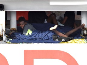 Migrants wait to disembark from Italian Coast Guard ship Diciotti in the port of Catania, Italy, Thursday, Aug. 23, 2018. A delegation from Italy's guarantor of personal rights office has boarded a coast guard ship in a Sicilian port with 150 African migrants stuck aboard for days, after the Italian interior minister vowed none will set foot on Italian soil.