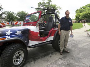 FILE - This June 2, 2018, file photo provided by the Kobach for Governor campaign shows Kansas Secretary of State Kris Kobach posing next to a Jeep mounted with a replica machine gun at the Old Shawnee Days Parade in Shawnee, Kan. Kobach is the GOP nominee in the gubernatorial race. Incumbent Gov. Jeff Colyer conceded the primary race late Tuesday, Aug. 14, 2018, and said he would endorse Kobach in the November election.