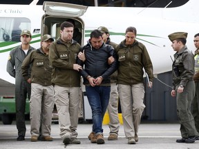 Police officers escort Franco Sepulveda off a plane, after he was detained in Antofagasta, for making multiple bomb threats about several airline flights, in Santiago, Chile, Friday, Aug. 17, 2018. Sepulveda caused nine commercial airline flights to take emergency measures. Police chief Mario Rojas said Sepulveda was angry because his suitcase was not returned.