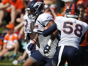 Denver Broncos linebacker Bradley Chubb, left, takes part in a drill with linebacker Von Miller at the team's NFL football training camp Monday, July 30, 2018, in Englewood, Colo.
