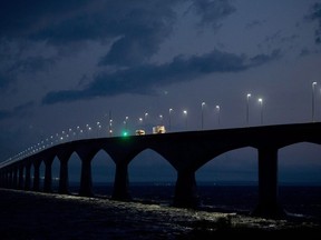 Ottawa has posted a tender asking engineering firms to assess how climate change and extreme weather will affect some of Atlantic Canada's major ferry terminals, airports and the Confederation Bridge. Trucks are seen crossing the Confederation bridge near Borden, P.E.I., late Wednesday, August 14, 2013.