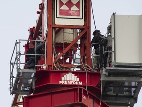 The case of a young woman who was charged after climbing a construction crane near Toronto's waterfront has been put over to next week. First responders are seen after rescuing a woman from a crane in downtown Toronto on Thursday, August 16, 2018.